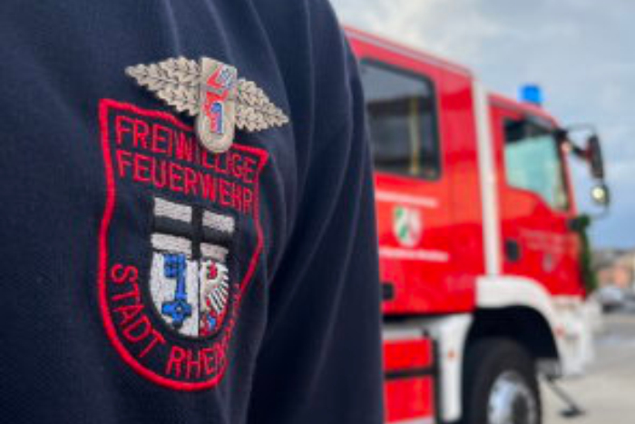 Foto eines Feuerwehrmannes vor einem Feuerwehrauto