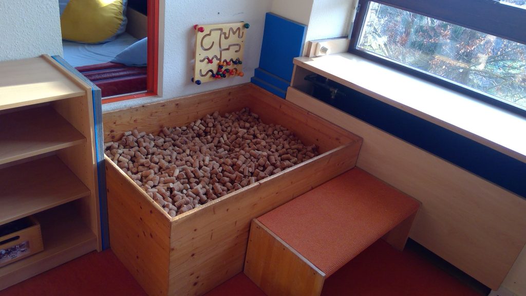 Gruppenraum mit einer Kiste voller Korken der Kita Schatzinsel der Stadt Rheinbach